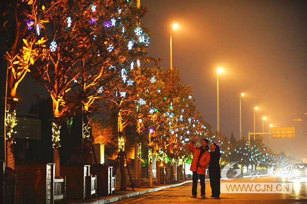 27日晚，在漢口沿江大道，兩位市民在景觀燈下合影。